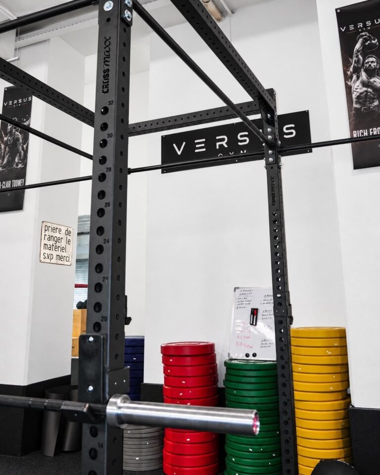 Rack de musculation et disques de couleur sous l'enseigne Versus Gym