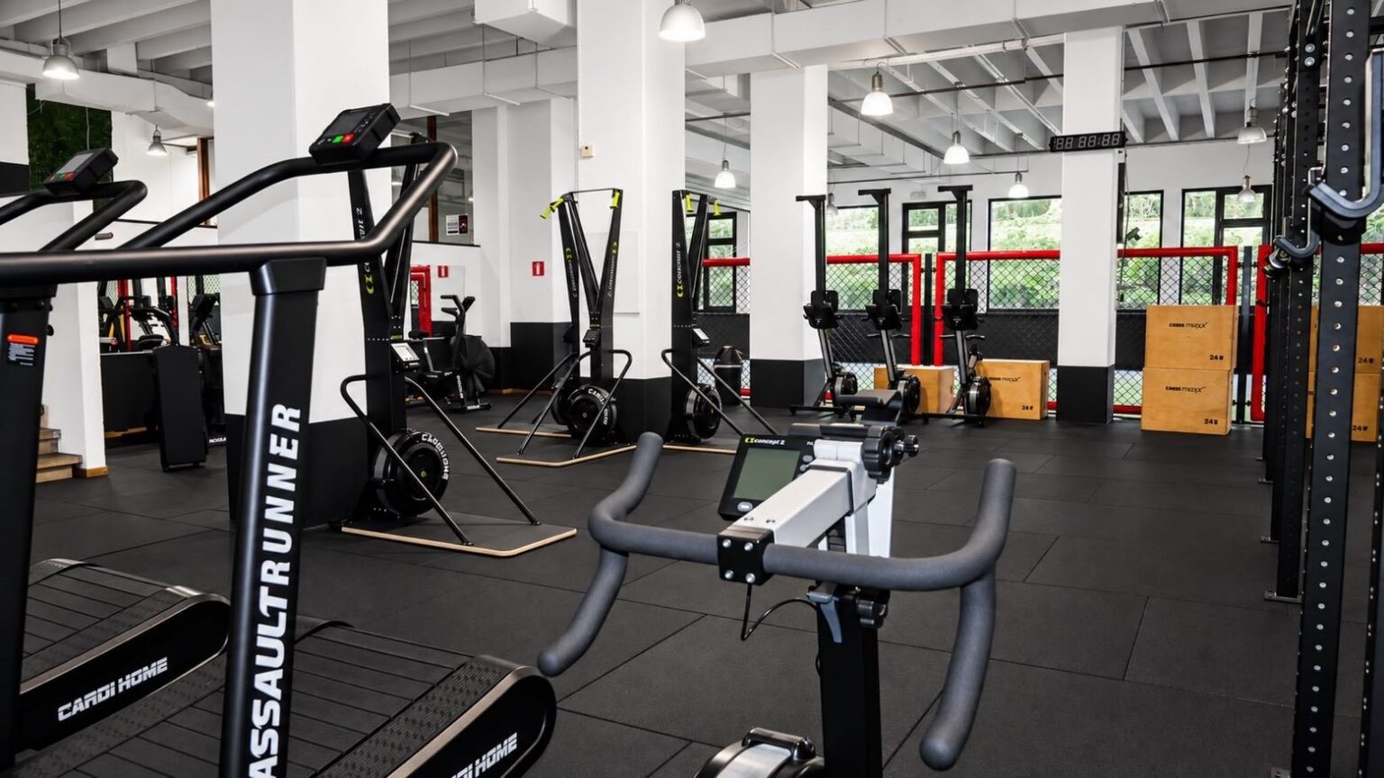 La salle Versus Gym vue depuis un vélo : SkiErg et rameurs alignés